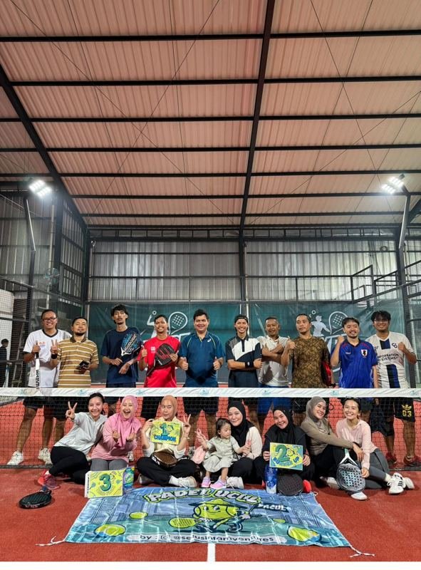 Komunitas Padel Ucul foto bersama di court Hype Padel Cibinong dengan spanduk dan raket